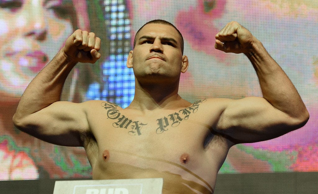 Mixed martial artists Cain Velasquez poses on the scale during his weigh-in for UFC 200