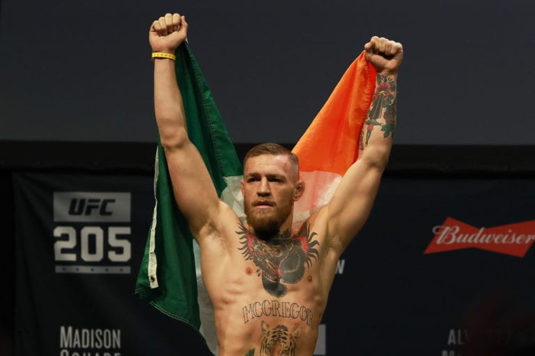 UFC Featherweight Champion Conor McGregor reacts as he walks on stage for UFC 205