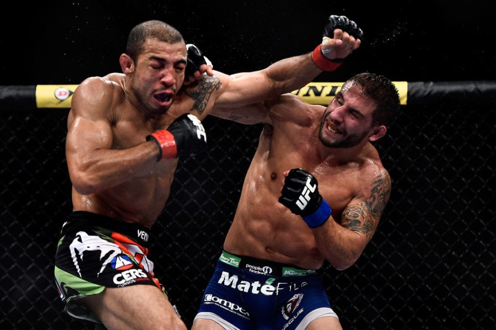 Chad Mendes of the United States punches Jose Aldo of Brazil in their featherweight championship bout during the UFC 179 event