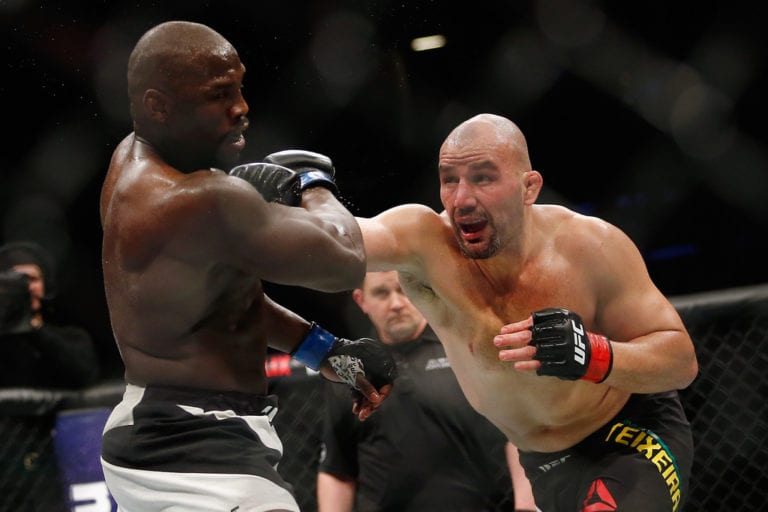 Glover Teixeira (R) of Brazil throws a punch against Jared Cannonier (L) of United Statesin their light heavyweight bout during UFC 208