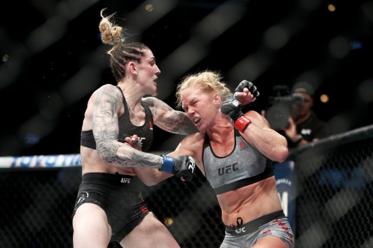 Holly Holm (L) punches Megan Anderson of Australia (L) in the fifth round in their featherweight bout during the UFC 225: Whittaker v Romero 2 event