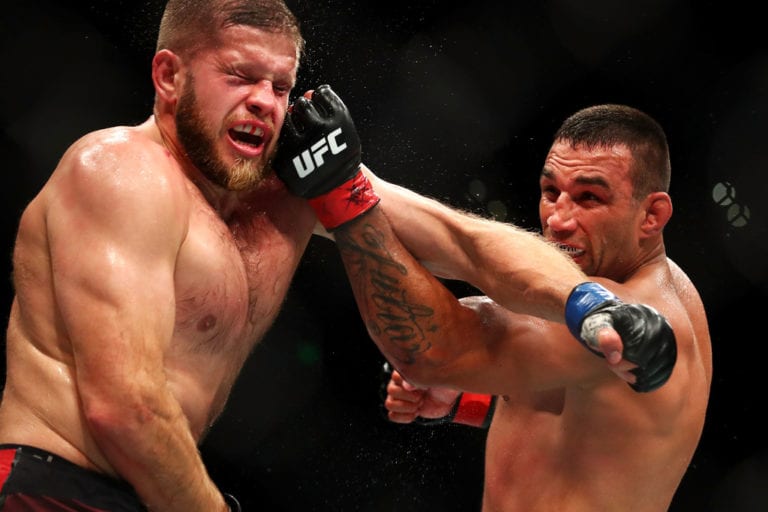 Fabricio Werdum (R) of Brazil punches Marcin Tybura of Poland in their heavyweight bout during the UFC Fight Night at Qudos Bank Arena on November 19, 2017