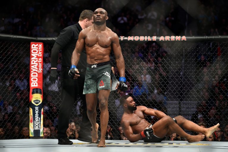 Kamaru Usman walks back to his corner after dominating Tyron Woodley at UFC 235
