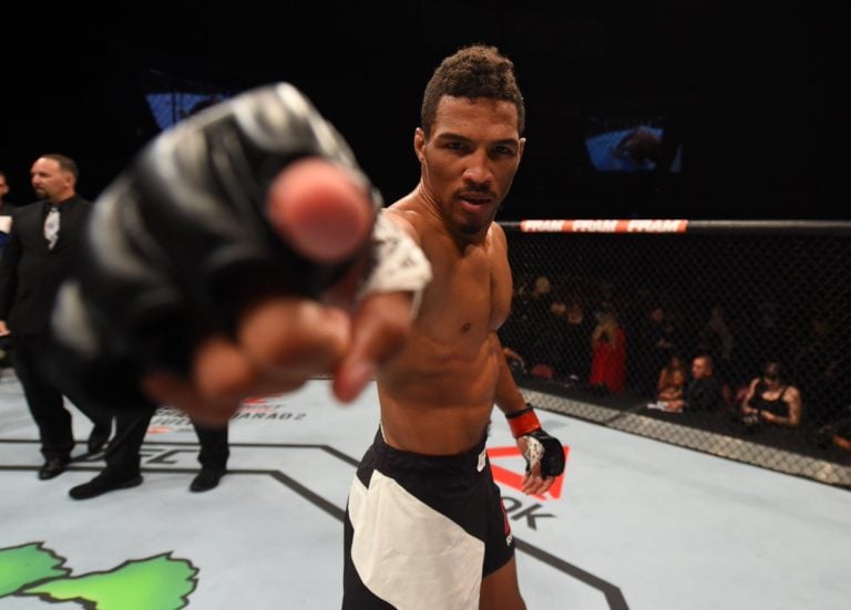 Kevin Lee points toward the camera inside the UFC Octagon