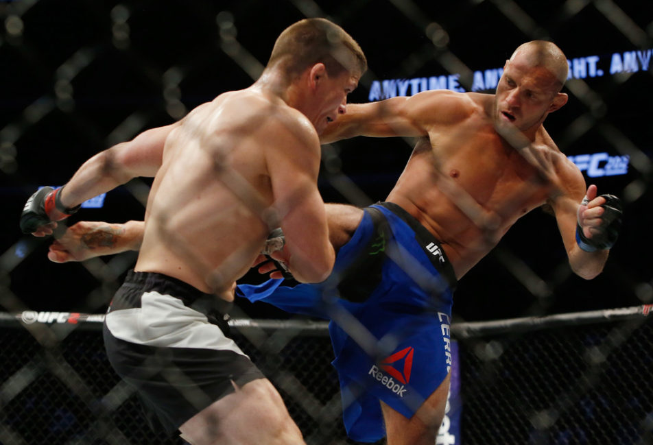 Donald Cerrone (R) kicks Rick Story during their welterweight bout at the UFC 202