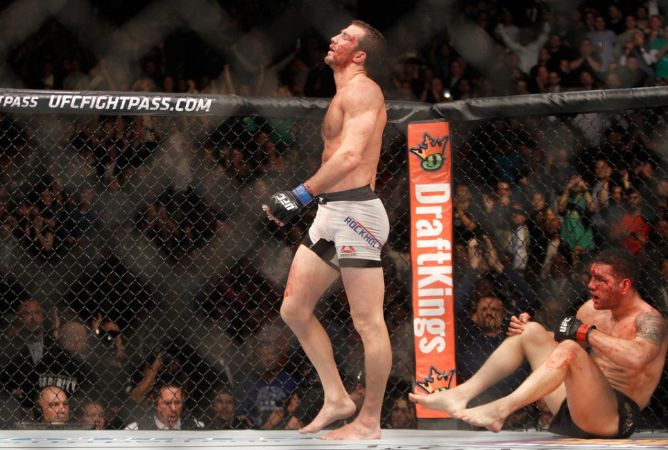 Luke Rockhold (L) walks away from a bloodied Chris Weidman after a fourth-round TKO