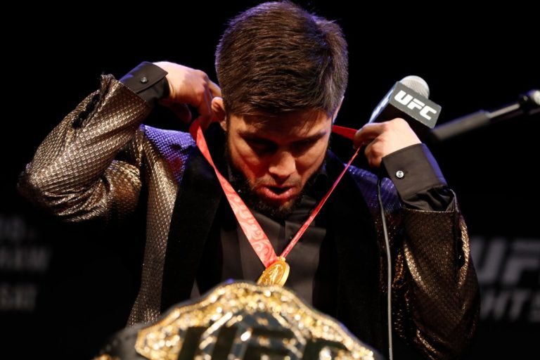 Henry Cejudo with his Olympic gold medal and UFC title