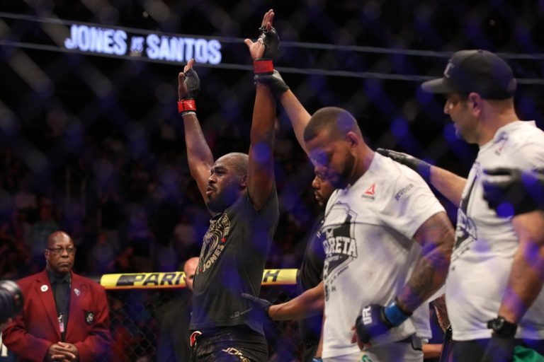 Jon Jones' hand is raised after defeating Thiago Santos