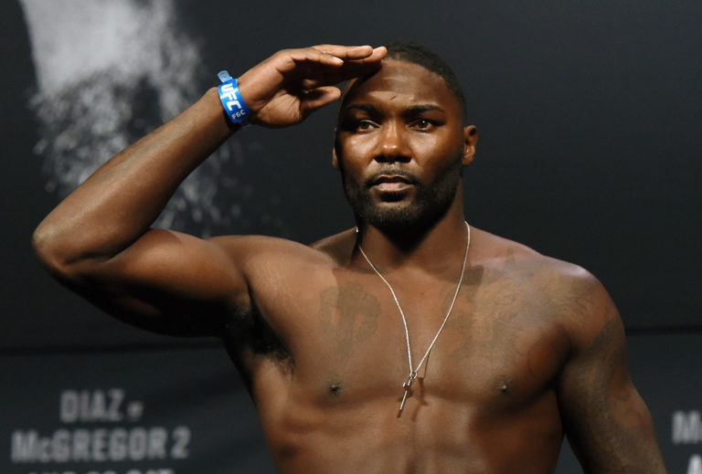 Mixed martial artist Anthony Johnson salutes as he poses on the scale during his weigh-in for UFC 202