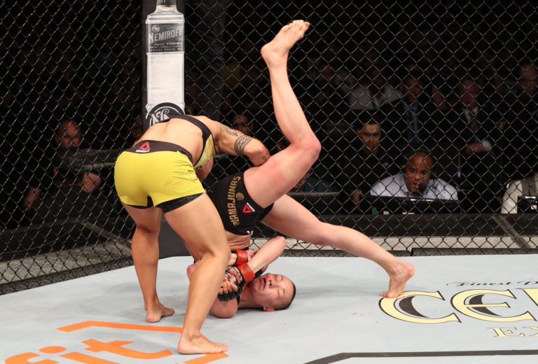 Jessica Andrade of Brazil slams Rose Namajunas, knocking her out, in their women's strawweight championship bout during the UFC 237 event