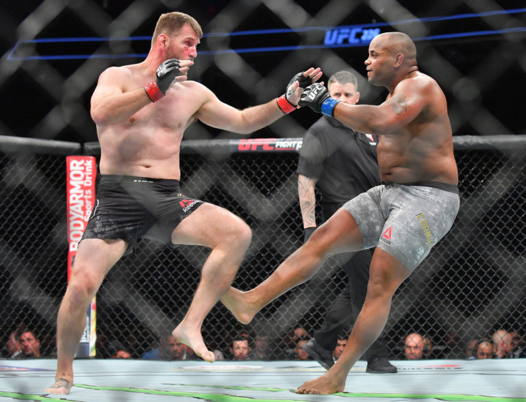 Daniel Cormier (R) kicks Stipe Miocic during their heavyweight championship fight