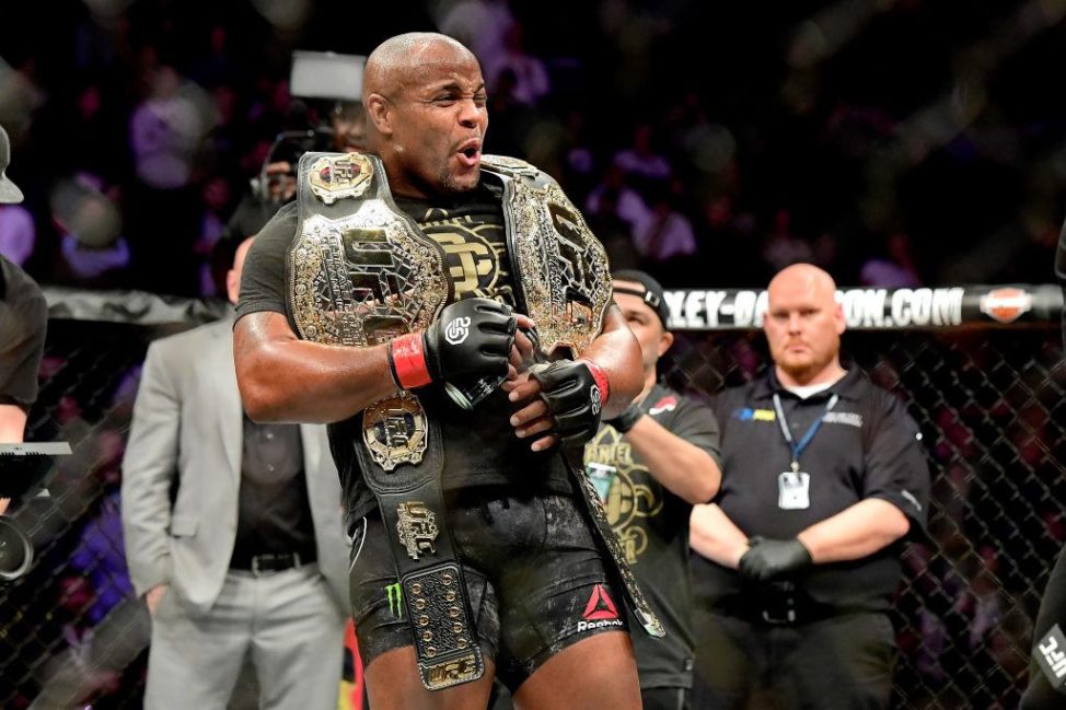 Daniel Cormier celebrates with his two UFC titles