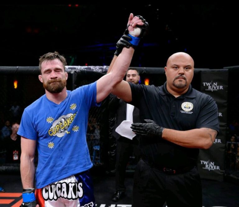 Johnny Campbell has his hand raised following a win at CES MMA