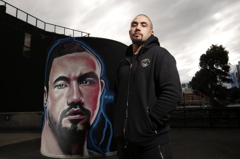 Robert Whittaker poses with street art